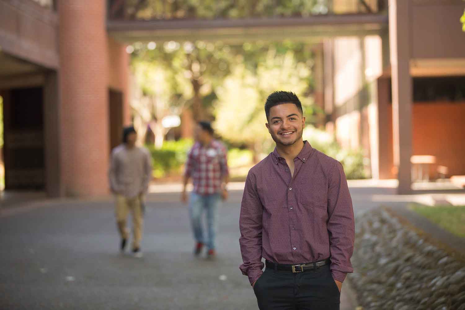 A Latino student enjoys the shade on campus